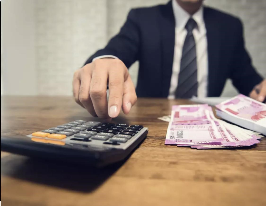 man punching income calculator